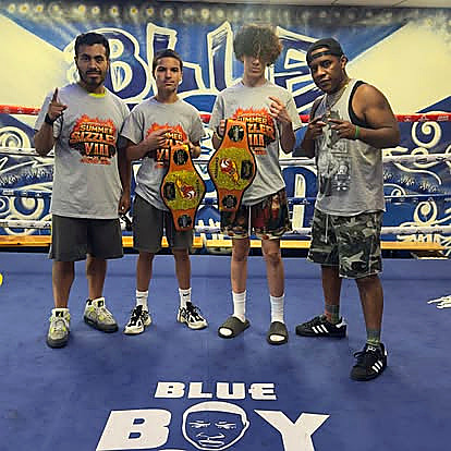 Blue Boy boxers with championship belts in the club ring